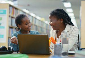 a teacher coaching a student in a library