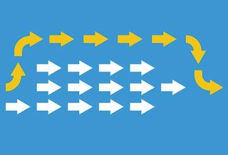 graphic of a group of white arrows pointing in the same direction on a blue background. from the back of them there is a yellow arrow that goes around the white ones to reach first