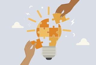 puzzle shaped like a lightbulb with two hands placing pieces