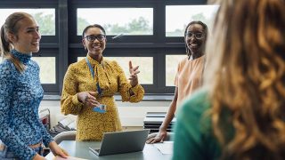 school teacher talking with her students in class